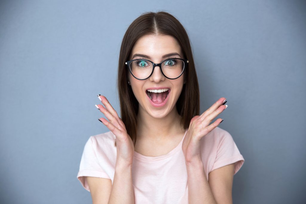 Surprised Young Woman In Glasses Over Gray Background Harish Marnad